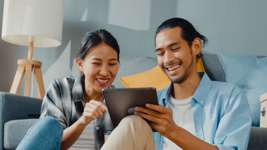 Young couple laughing and using an iPad