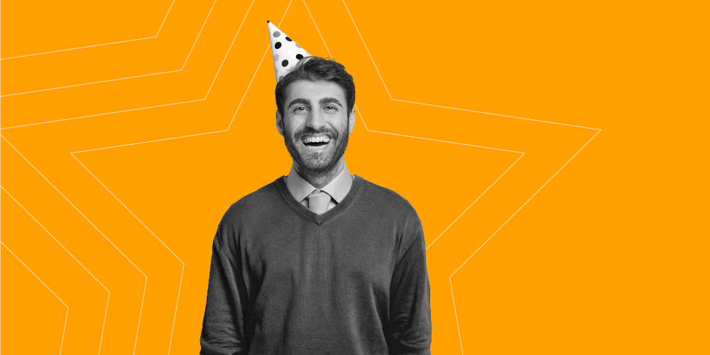 Man smiling while wearing a birthday hat