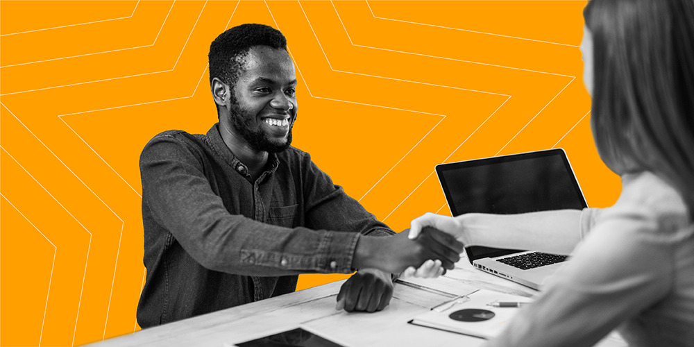 Man shaking hands with woman at desk