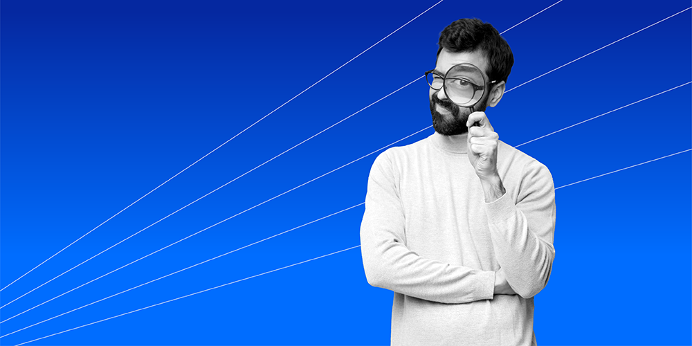 man with glasses looking through a magnifying glass to see 4 COVID-19 financial scams that target Gen Z