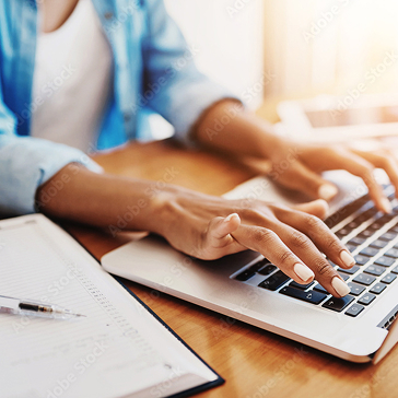 Hands typing on a laptop