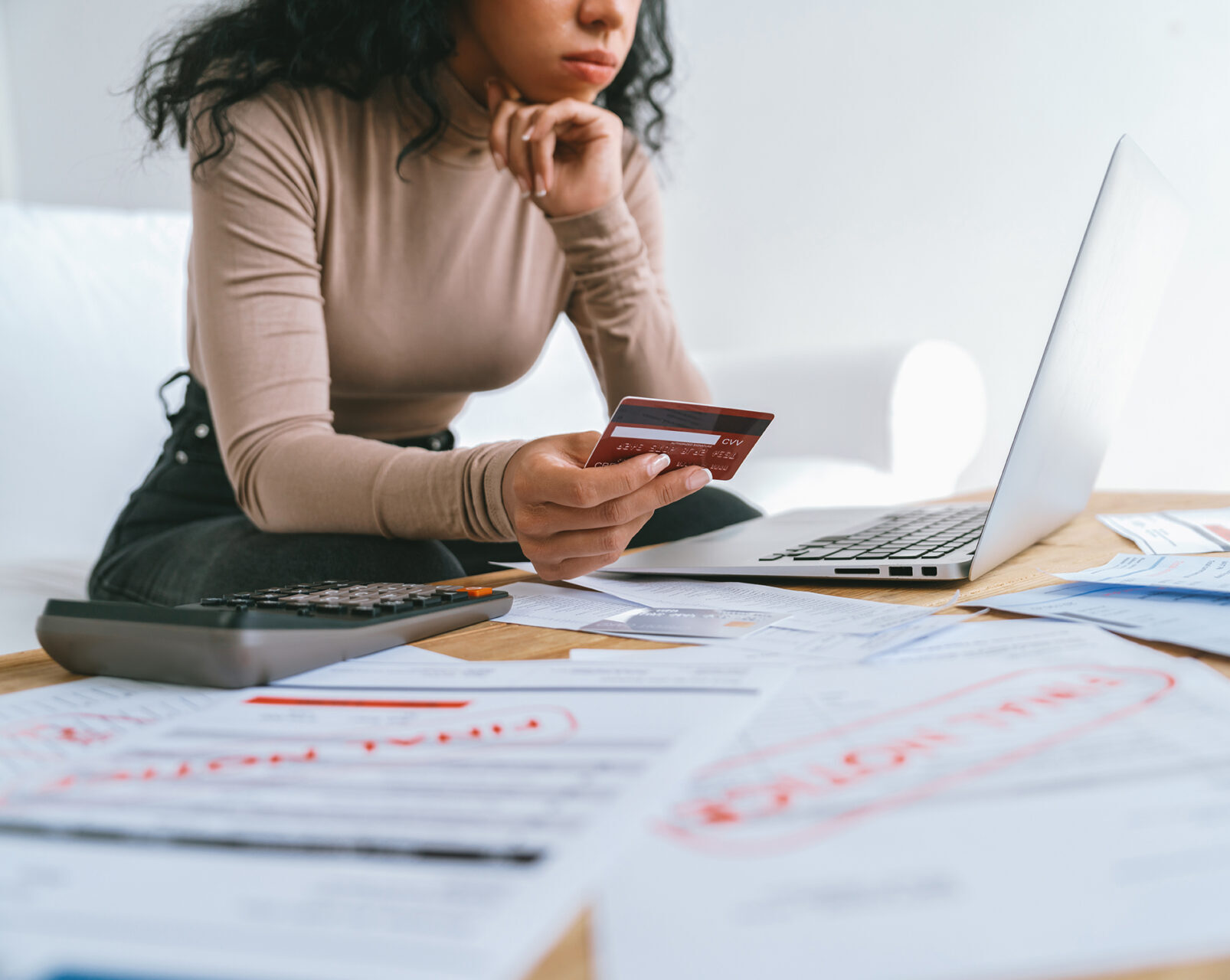 Woman working on computer and holding a credit card