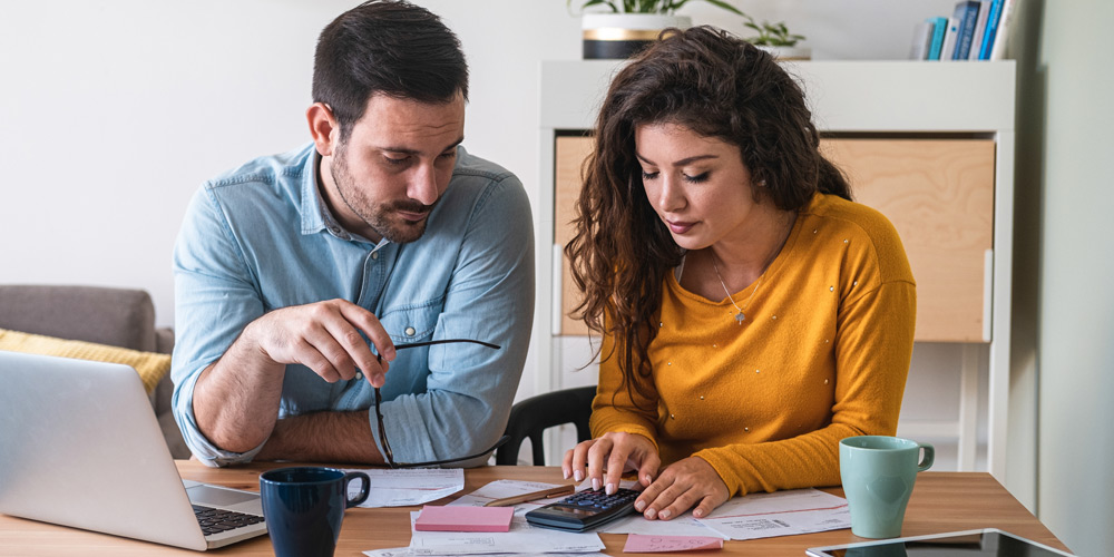 Man and woman using a calculator at a desk