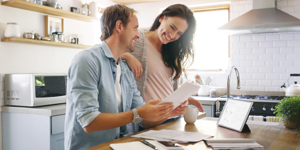 Couple looking at documents with coffee in the kitchen