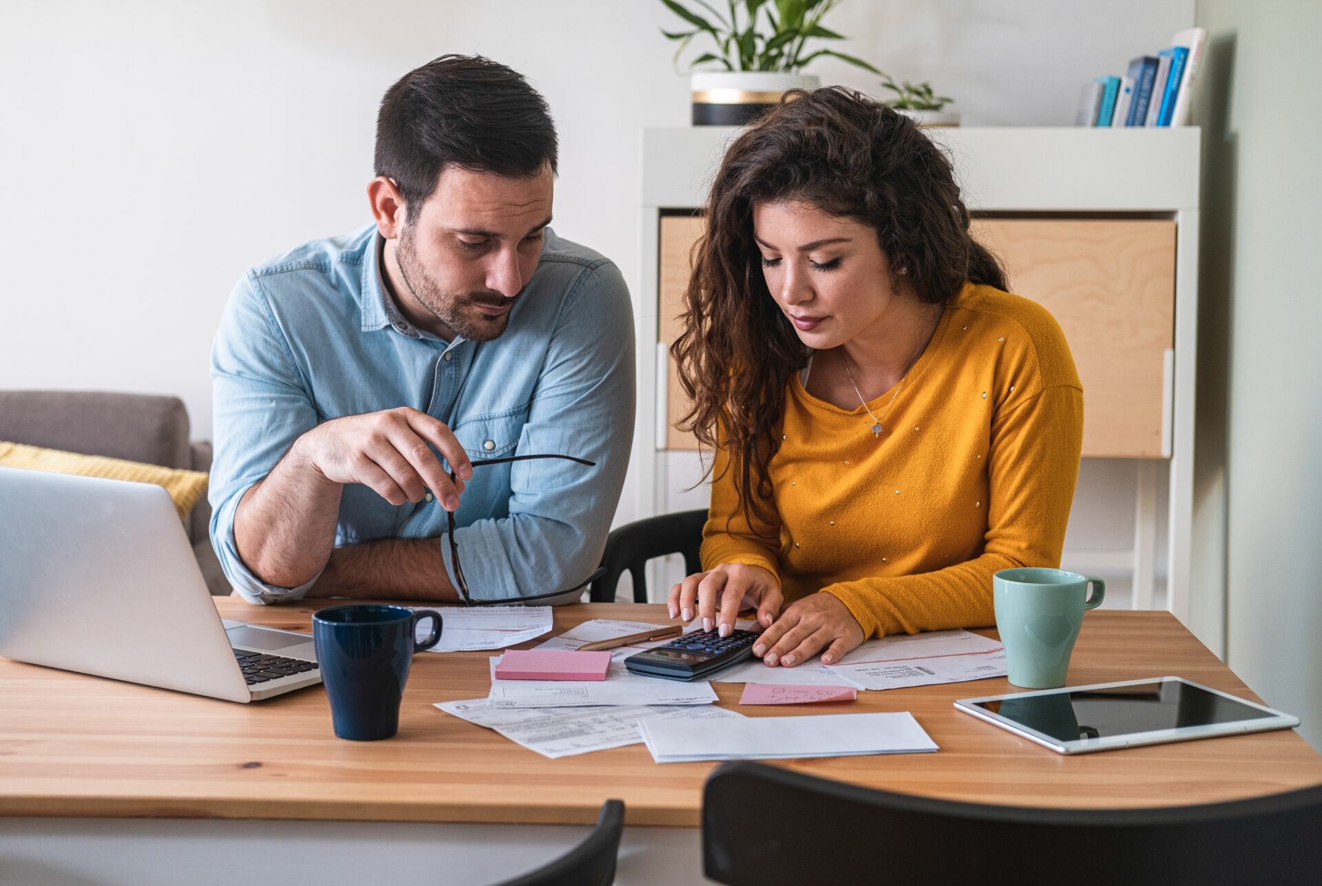 Man and woman using a calculator at a desk