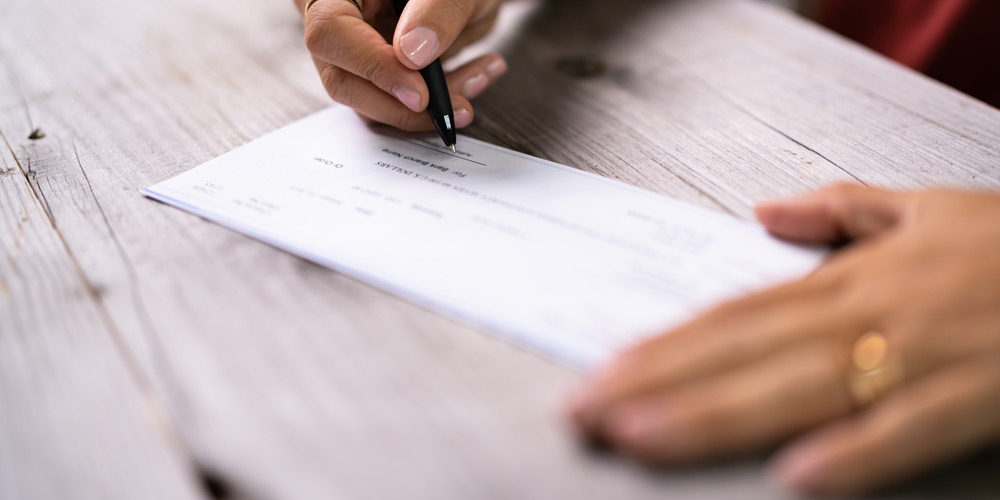 Hands signing a check